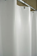 White vinyl shower curtain hanging on a shower curtain rod.